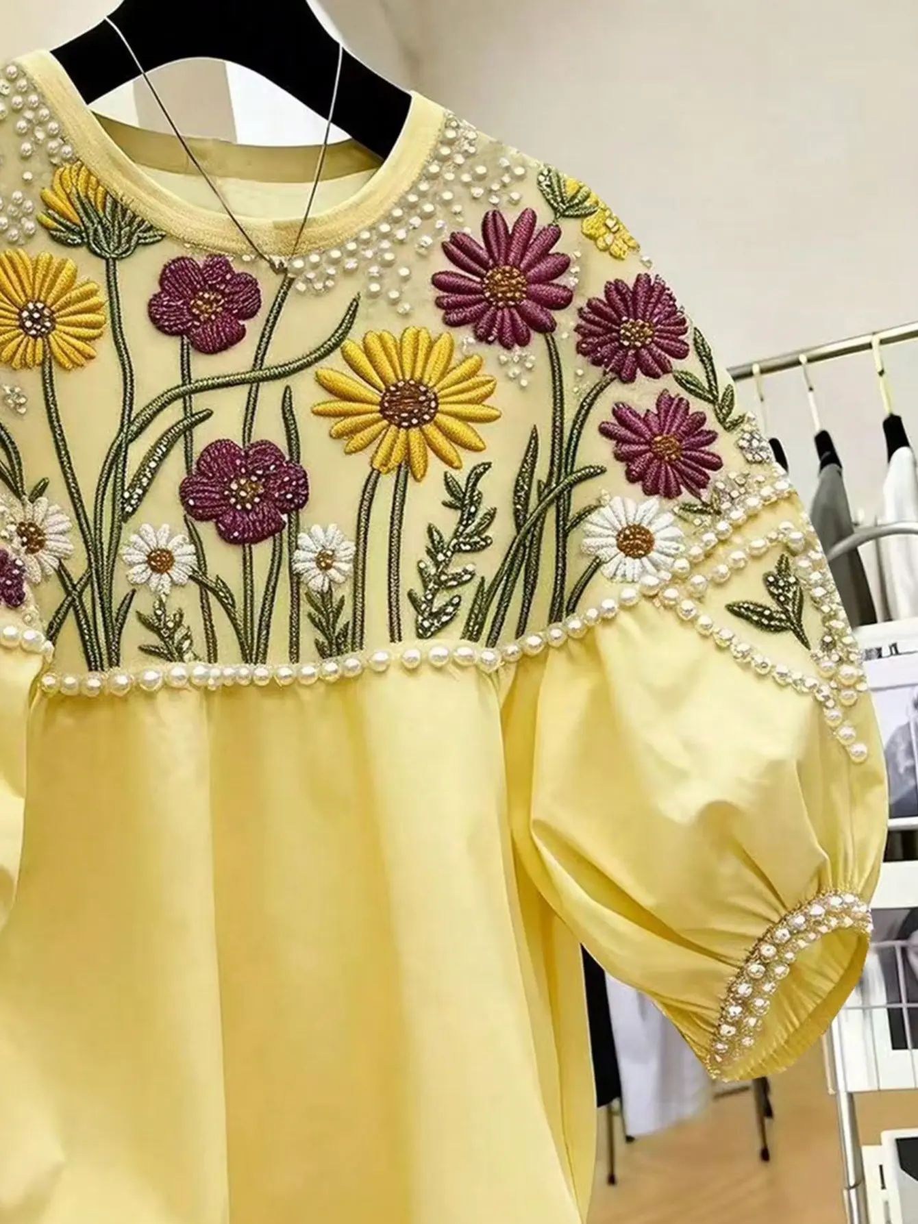 Close-up of daisy embroidery on yellow top