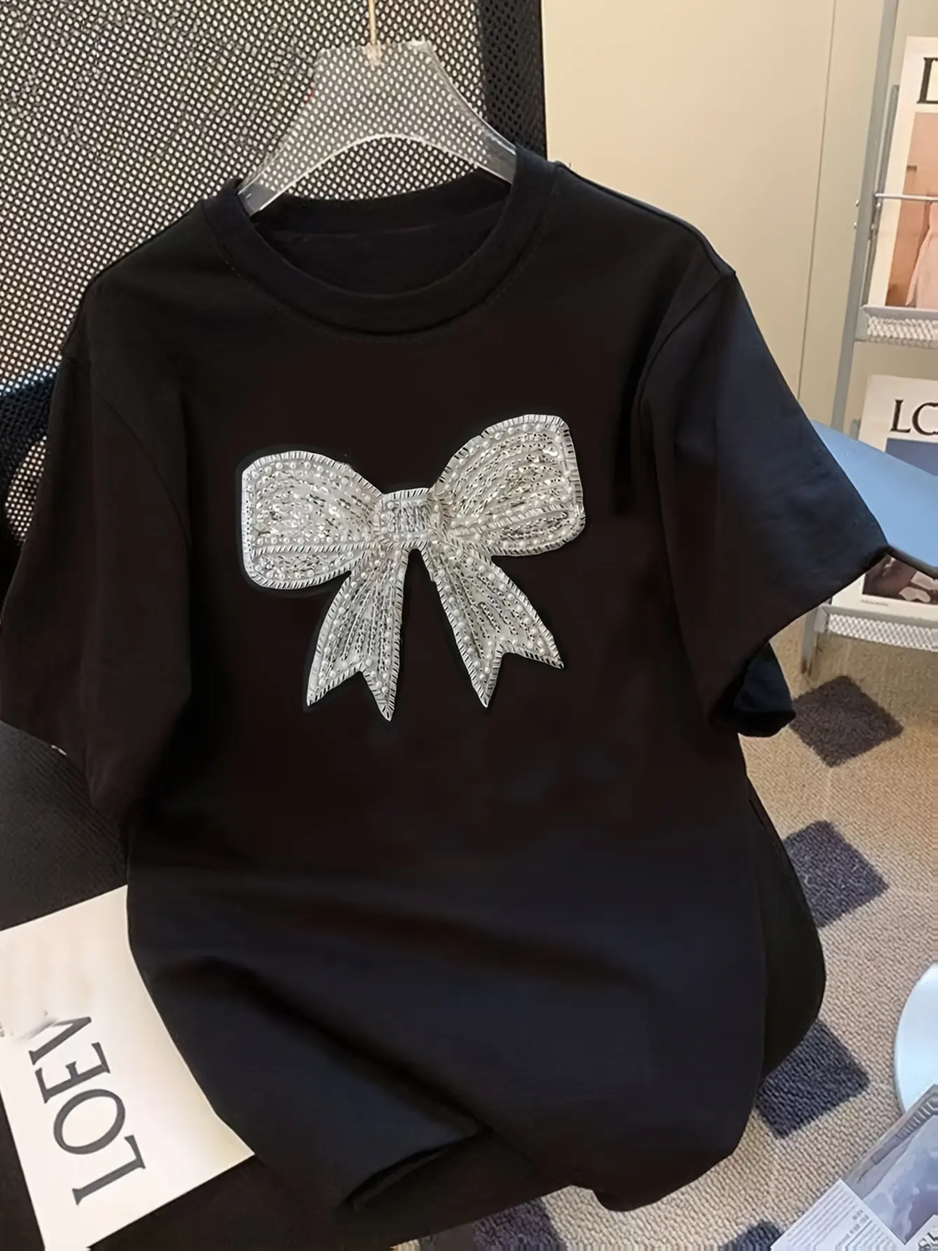 Black crew-neck T-shirt with silver bow applique