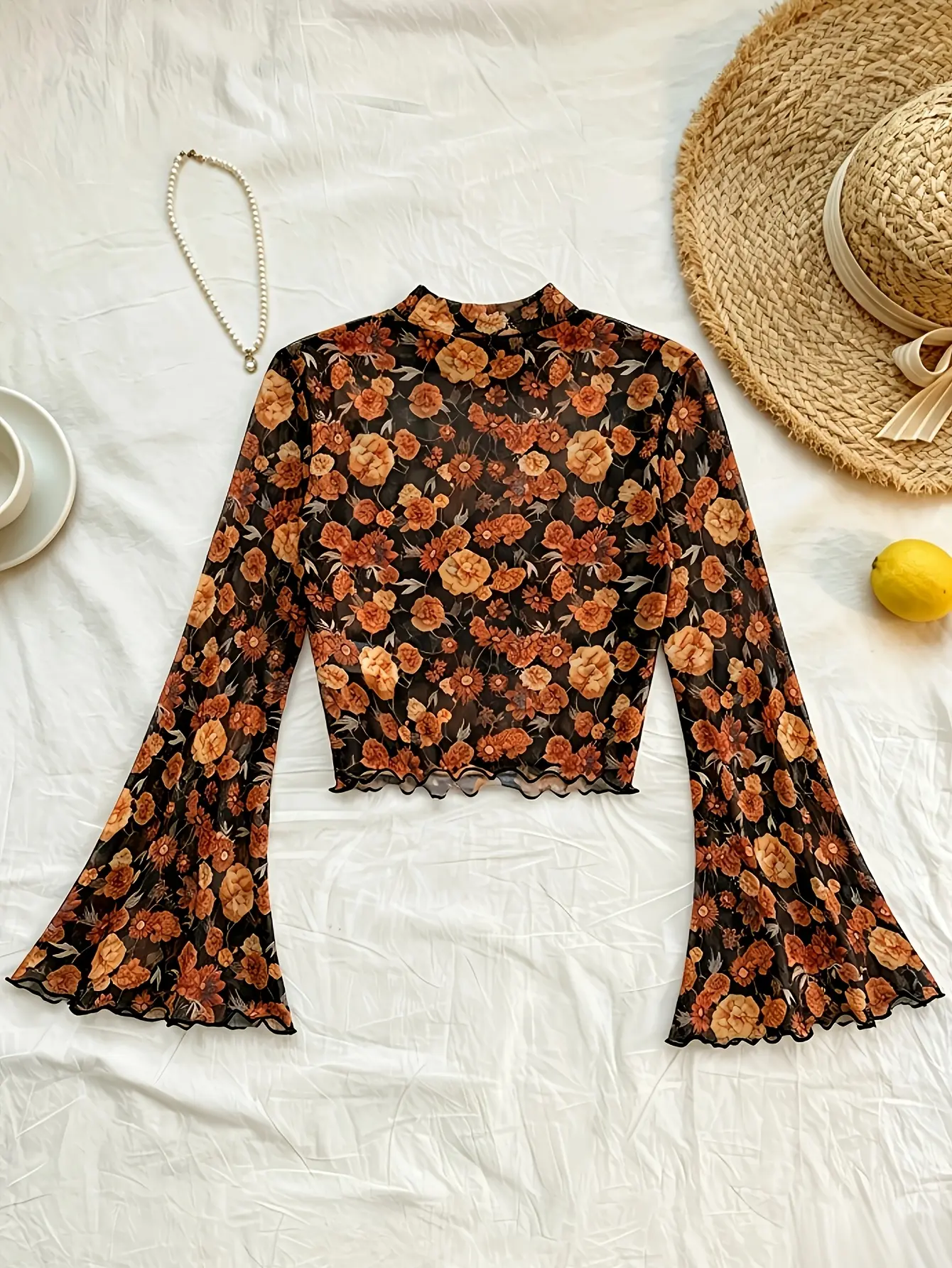 Black floral mock-neck bell-sleeve mesh top laid flat