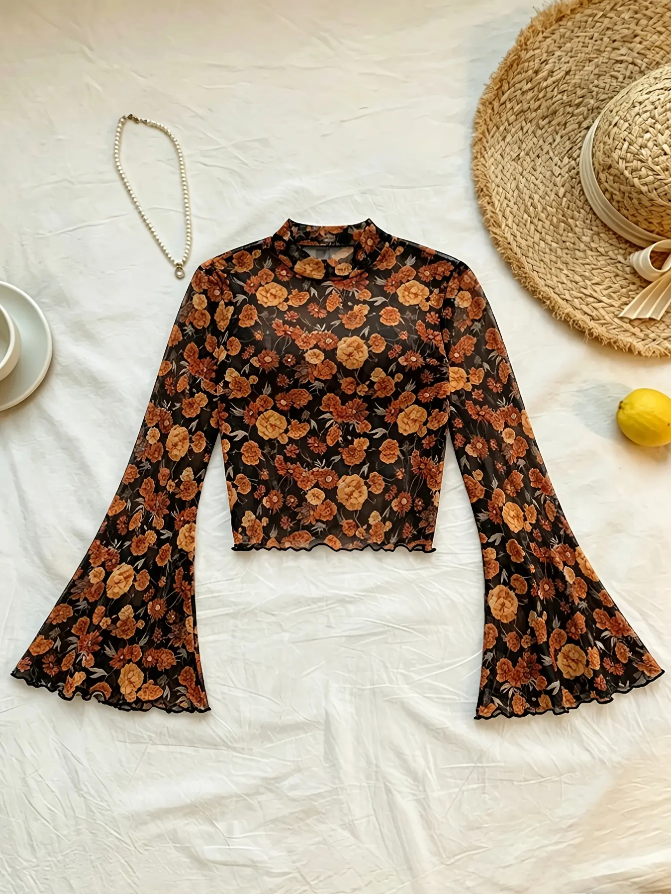 Black floral mock-neck bell-sleeve mesh top laid flat