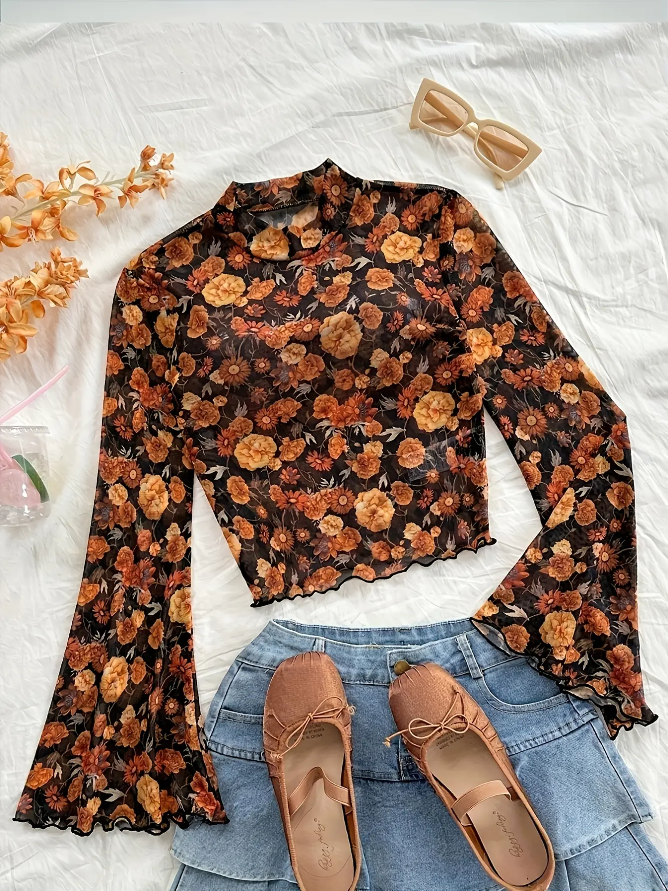 Black floral mock-neck bell-sleeve mesh top laid flat