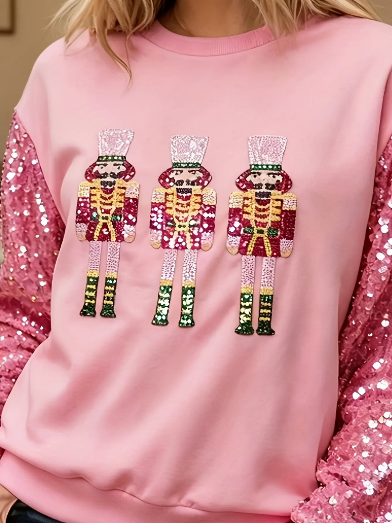 Close-up of nutcracker embroidery on pink sweatshirt