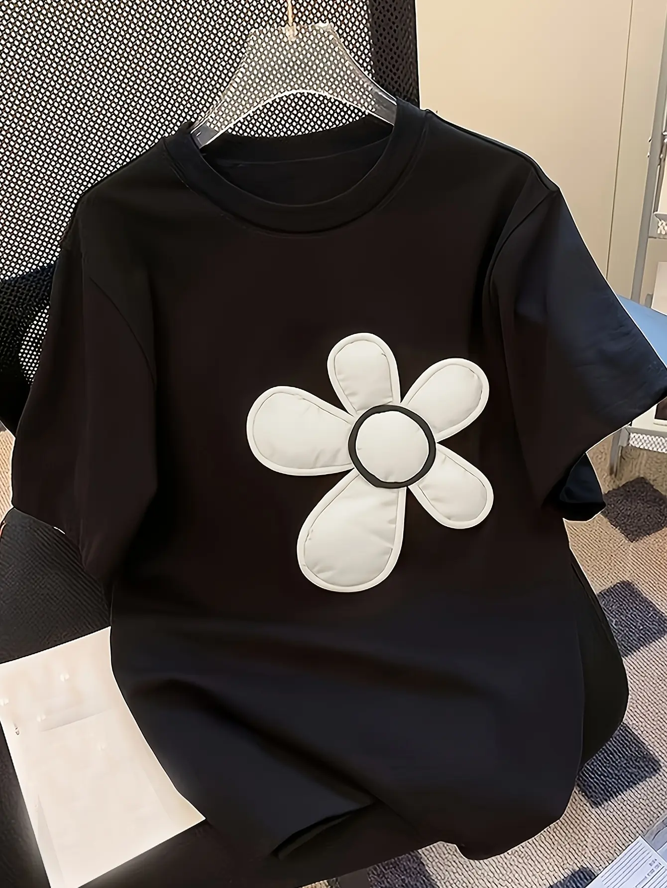 Black crew-neck top with white flower applique